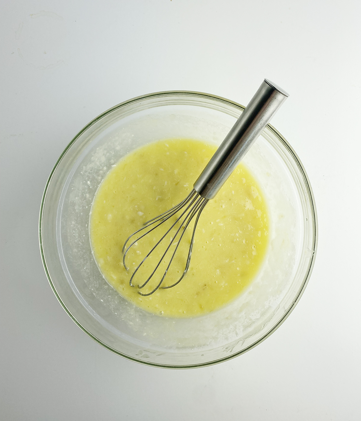 Banana and egg mixture in a mixing bowl.