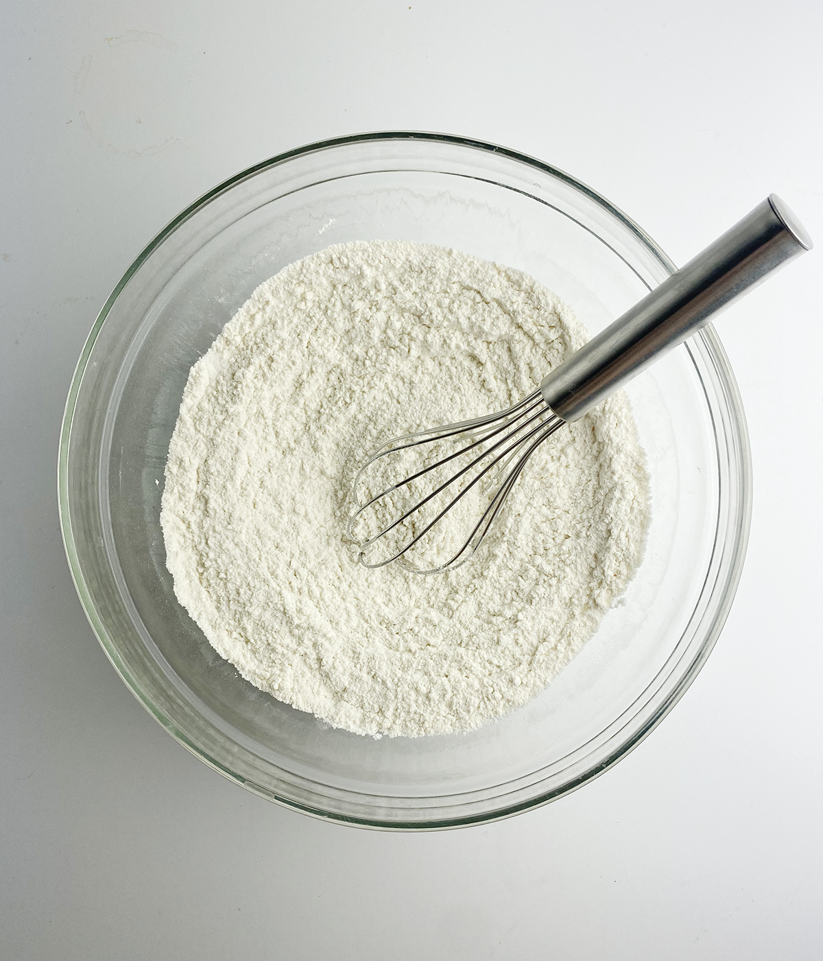Flour mixture in a mixing bowl with a whisk.