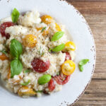 Tomato basil mozzarella risotto on a plate.