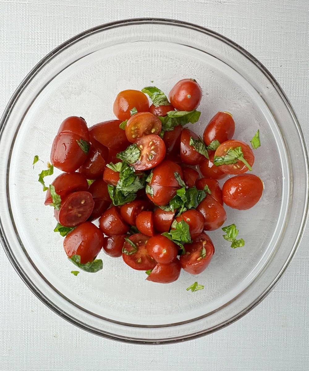 Tomatoes basil and olive oil marinating in a bowl.