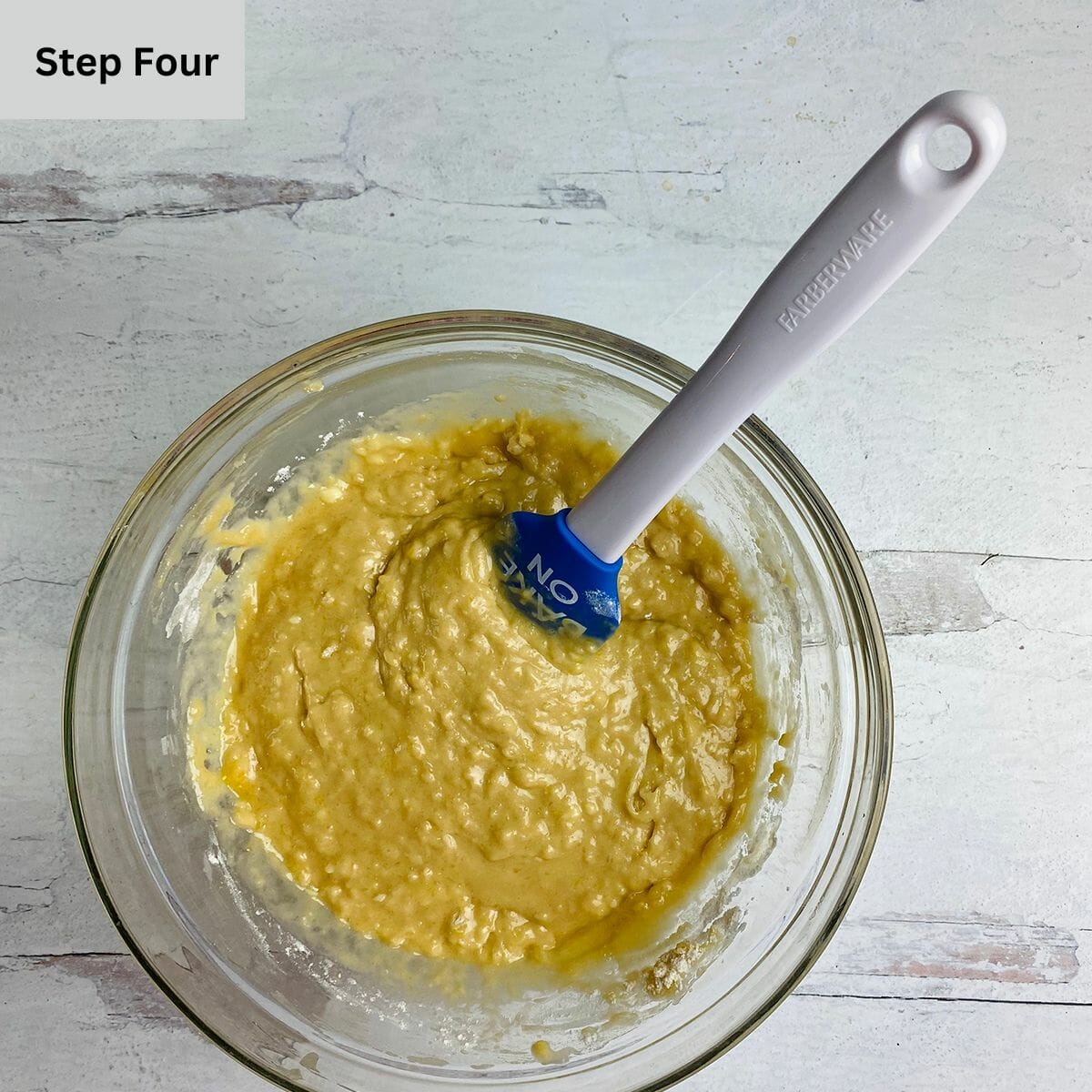 Maple muffin batter in a mixing bowl with a spatula.