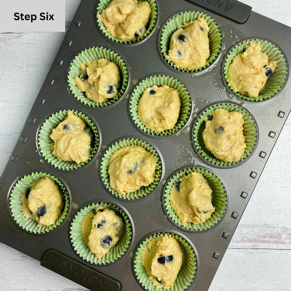 Maple blueberry muffin batter in a muffin tin ready for baking.