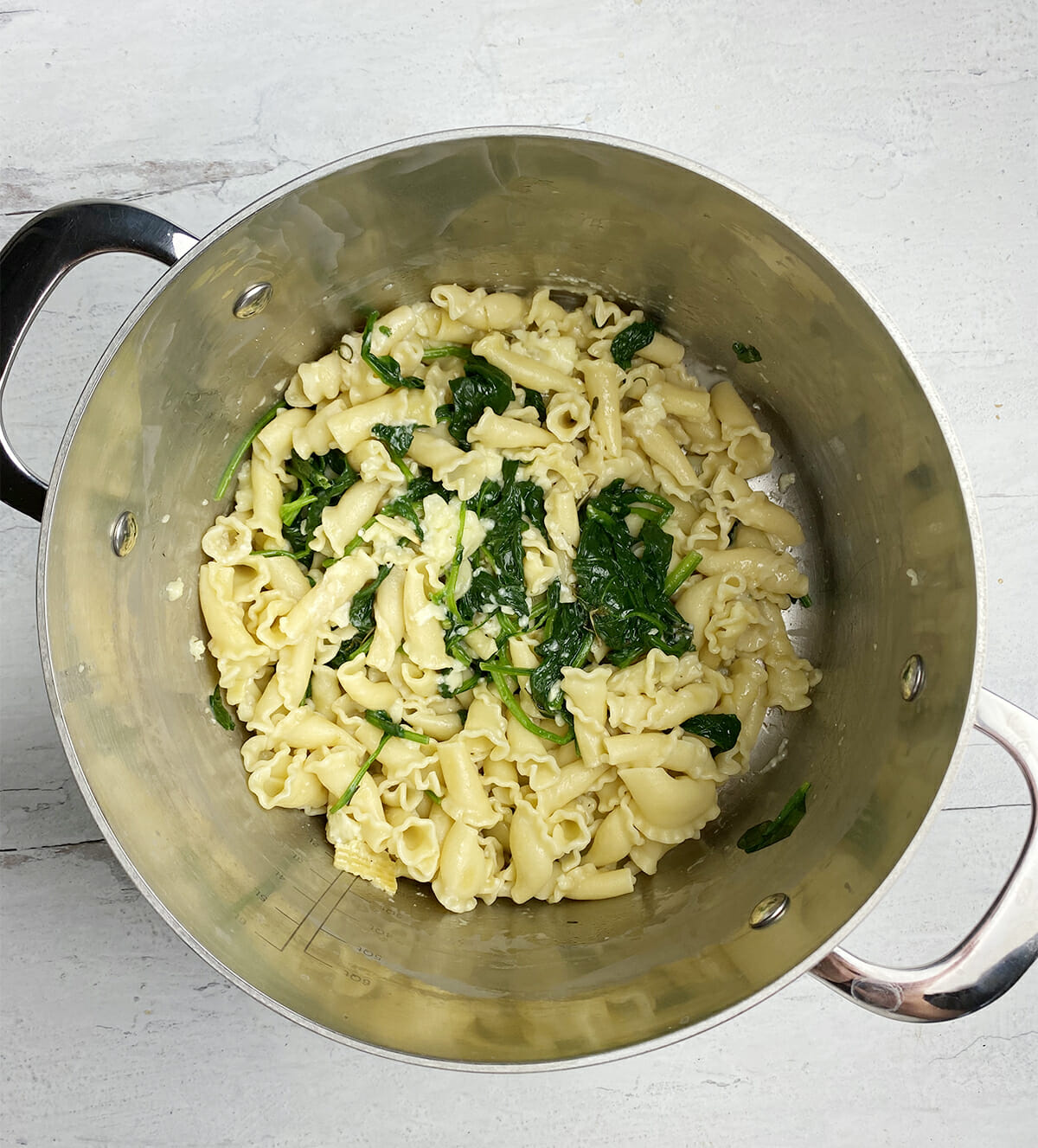 Pasta with camembert mixture in a pot.