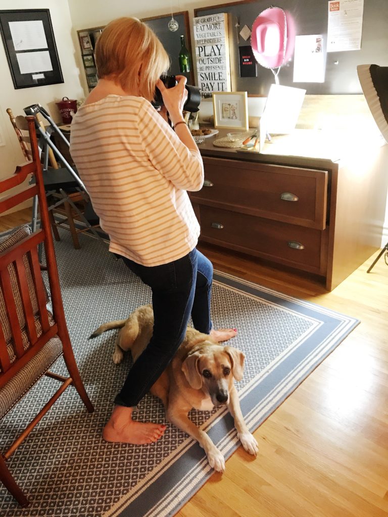 photographer with dog underfoot