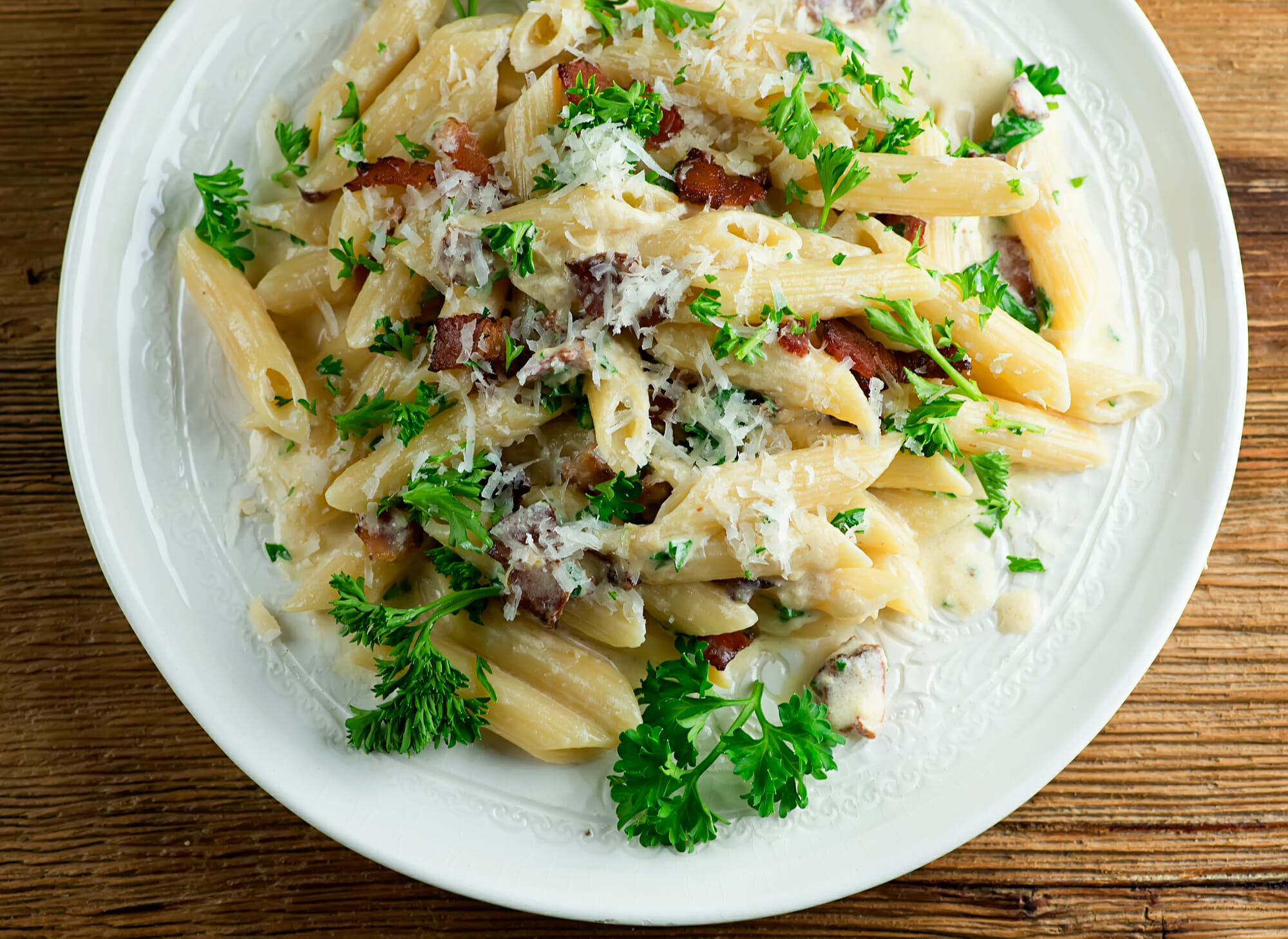 Penne pasta with bacon on a plate.