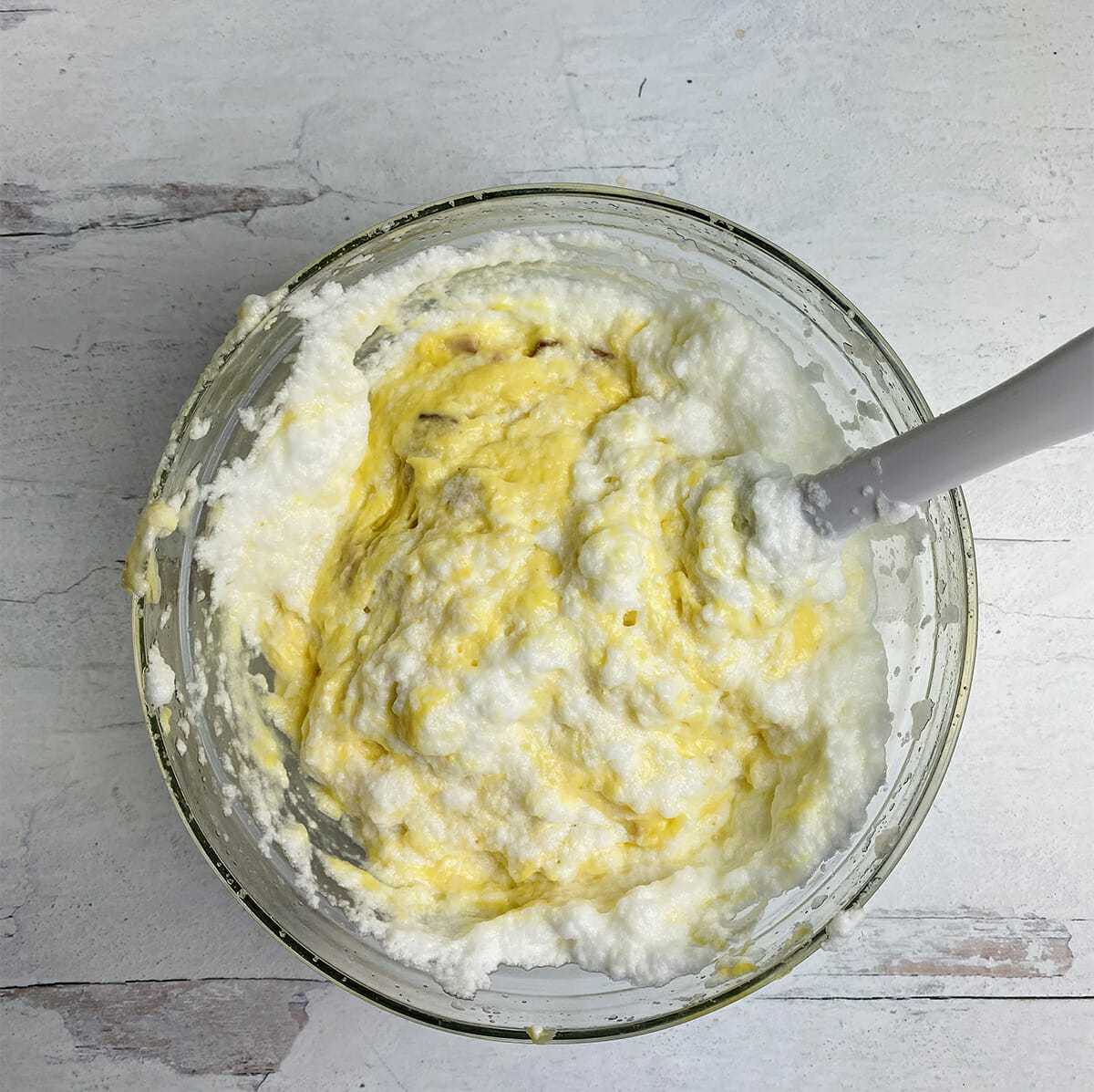 Folding egg whites into souffle mixture.