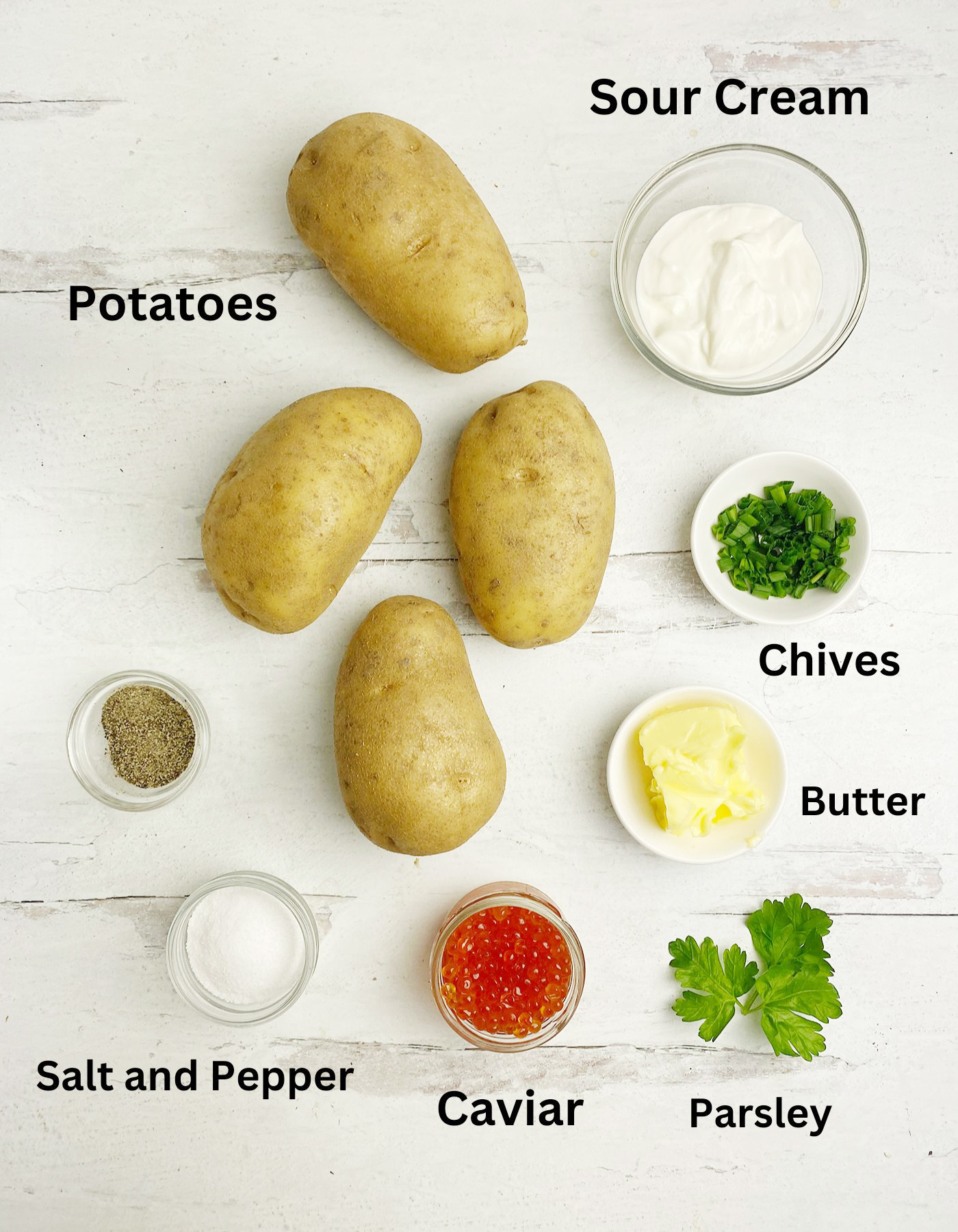 Ingredients for caviar potatoes on a wooden counter.