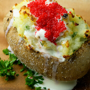 A baked potato topped with caviar and sour cream.