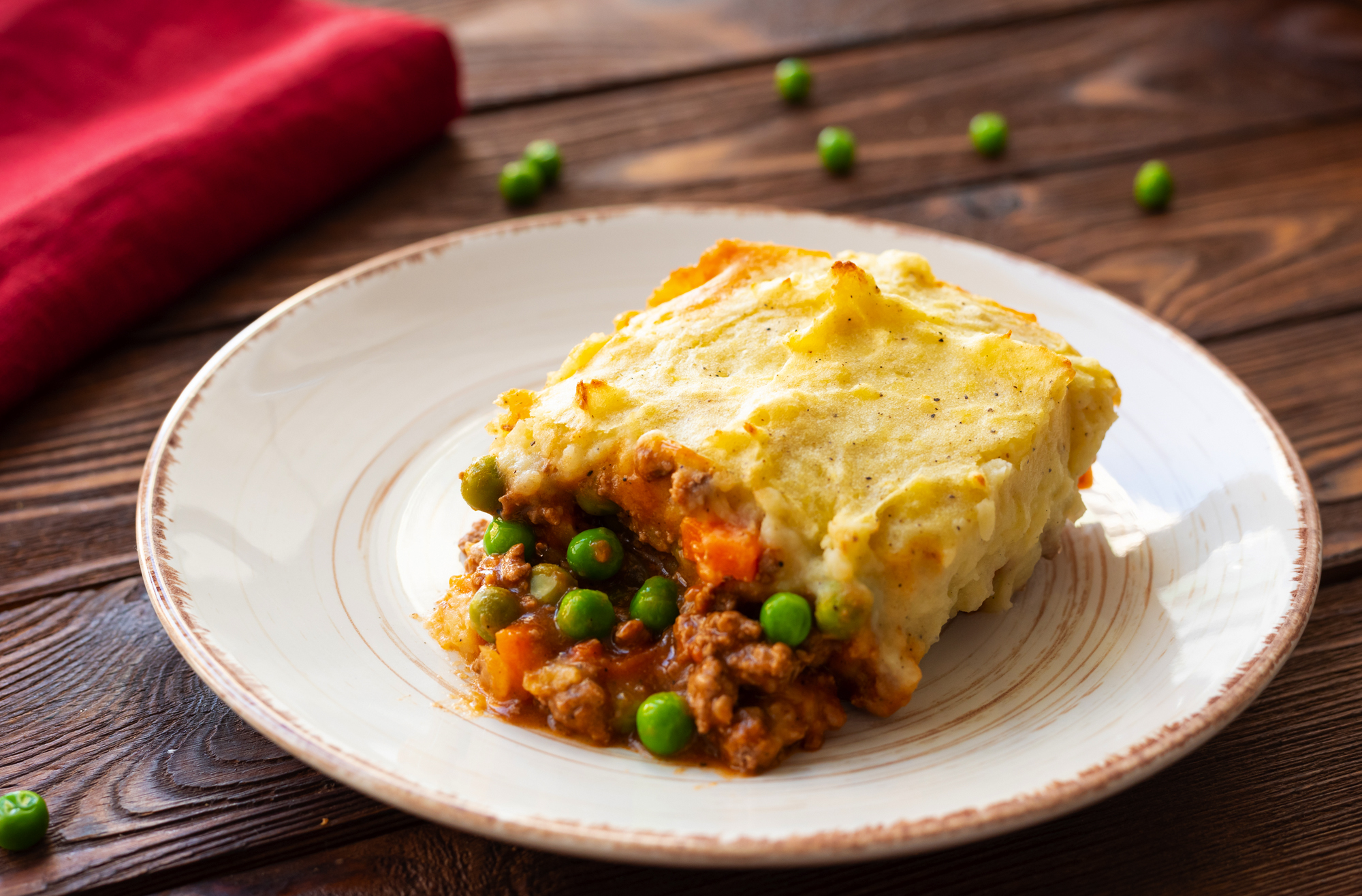 fresh out of the oven single serving of shepherd's pie on a white plate.