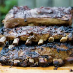 Coca cola ribs resting on a board.