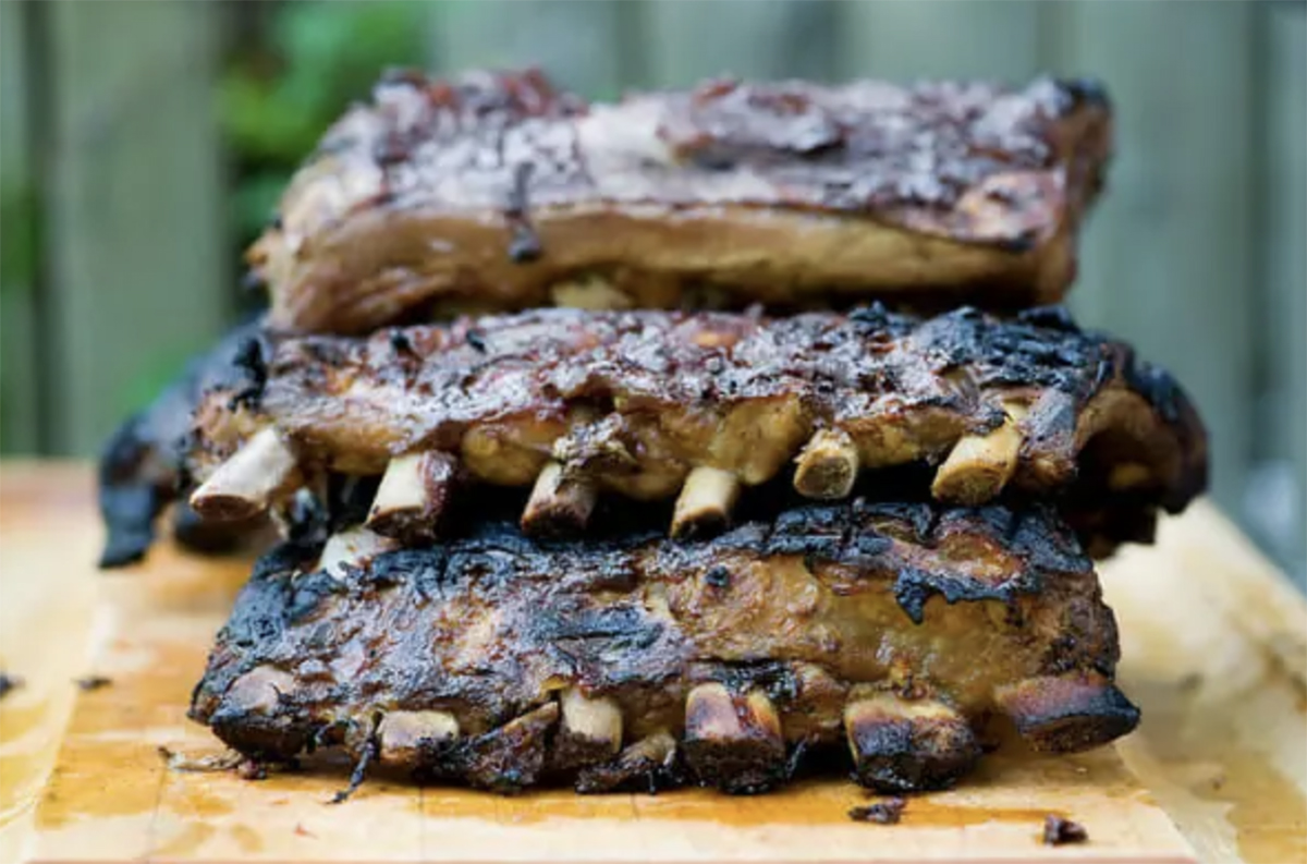 Coca cola ribs resting on a board.