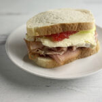 Fancy ham and cheese sandwich on a plate.