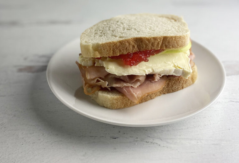 Fancy ham and cheese sandwich on a plate.