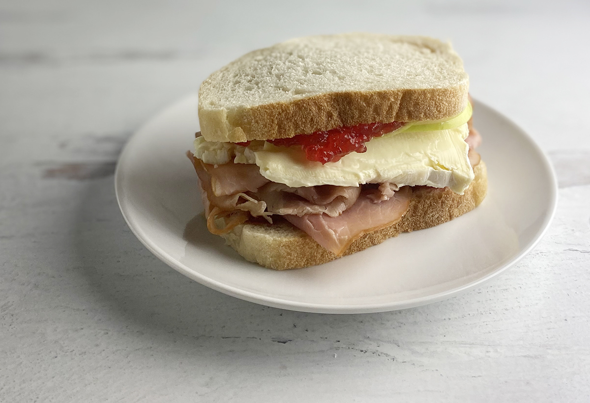 Fancy ham and cheese sandwich on a plate.
