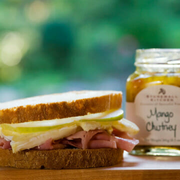 Ham and Brie sandwich on a wooden board.