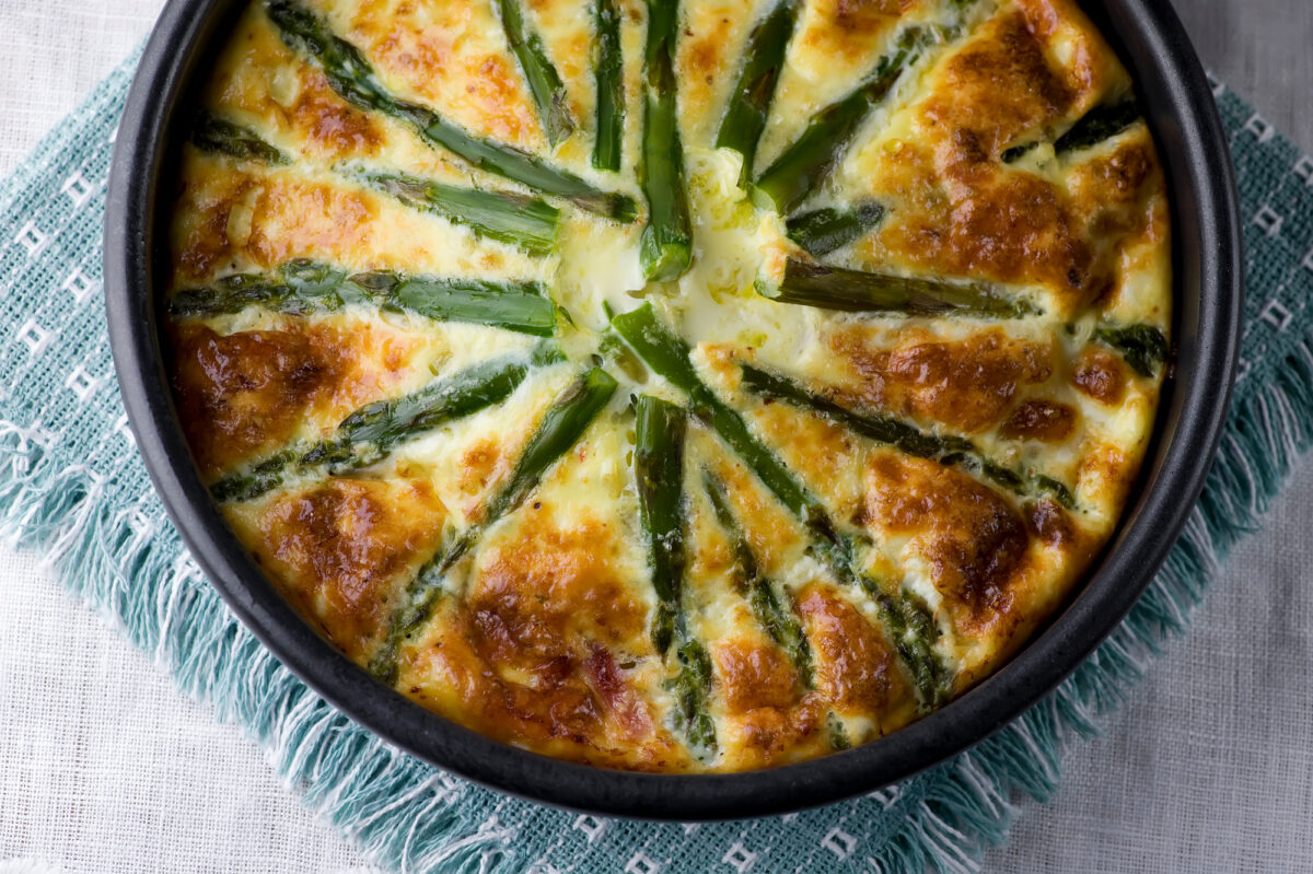 Ham and cheese oven frittata on a blue cloth.