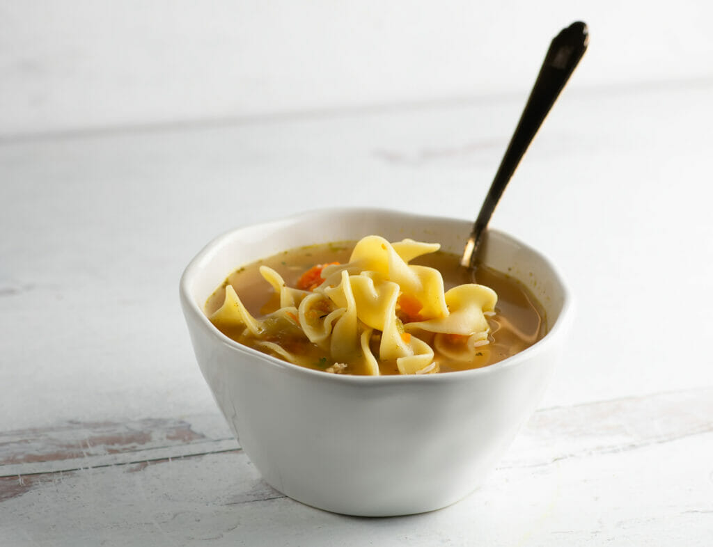 Chicken noodle soup on a bowl with a spoon.