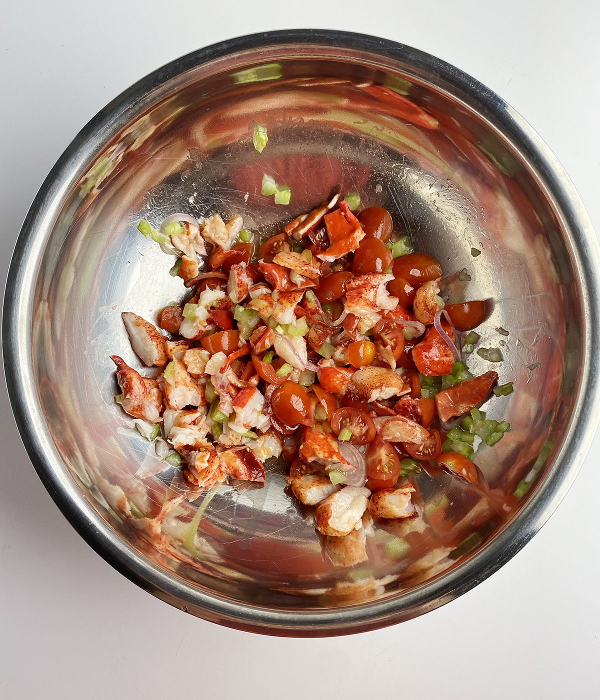 Lobster bruschetta mixture in a metal mixing bowl.