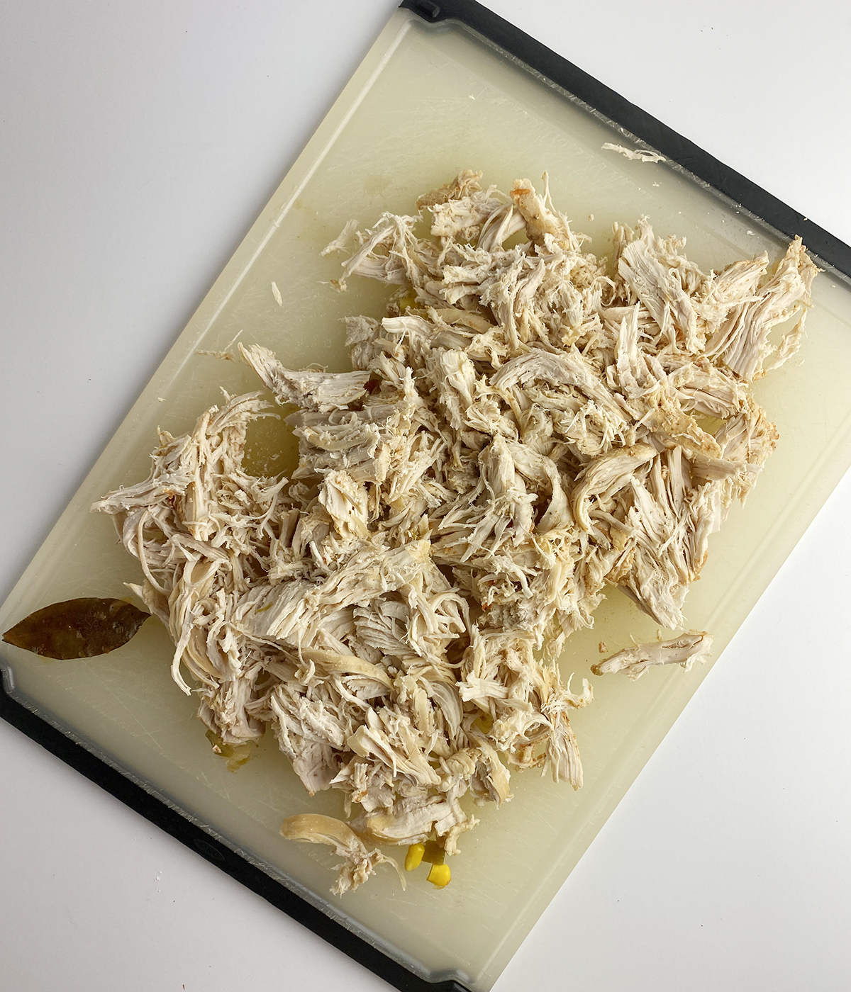 Shredded chicken on a cutting board.