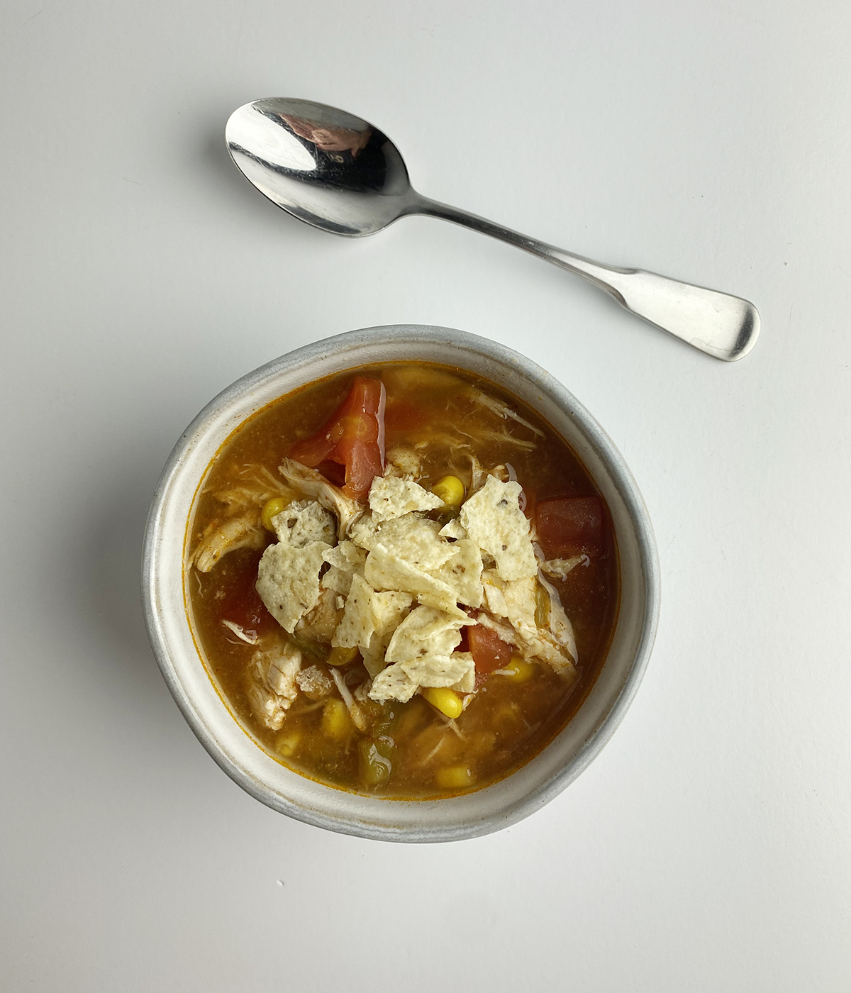 Slow cooker chicken tortilla soup with a spoon.