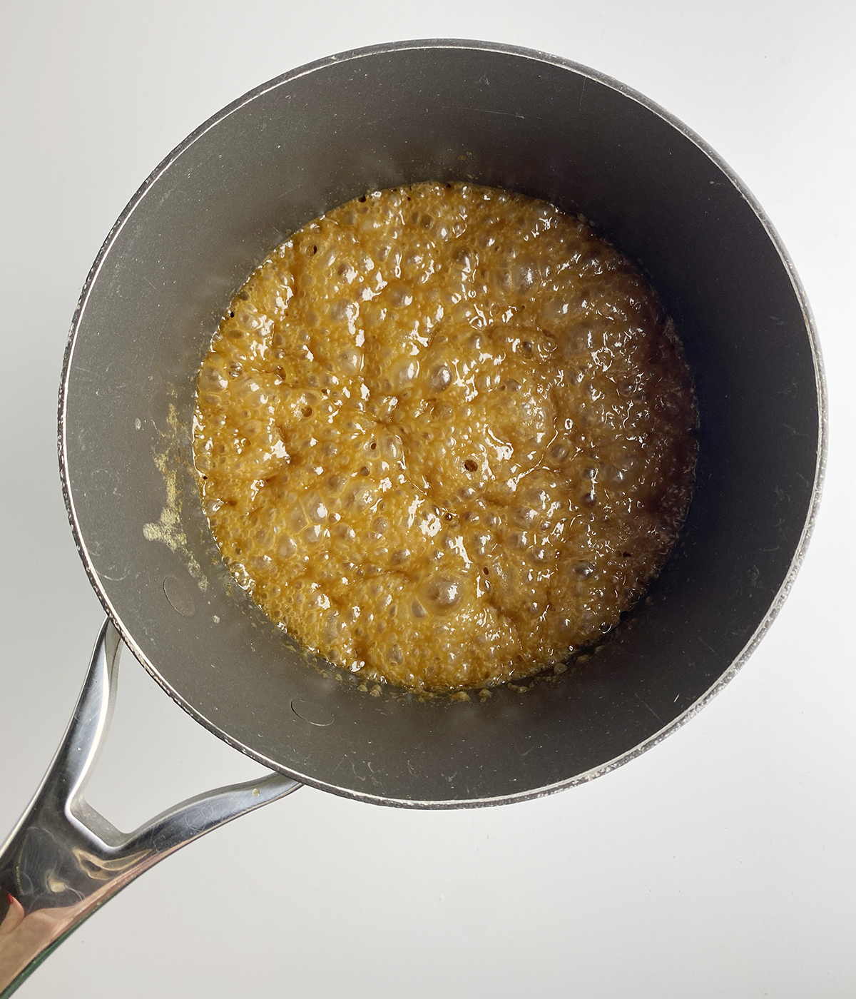 Bubbling caramel sauce in a pot.