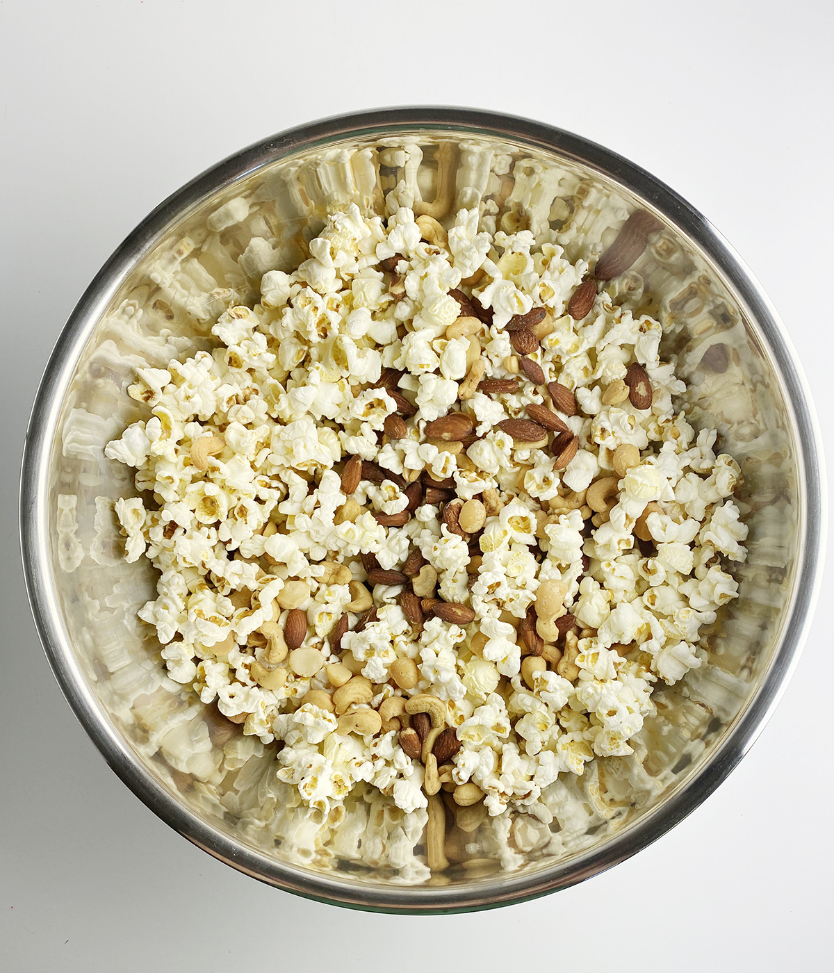 Popcorn and mixed nuts in a metal bowl.