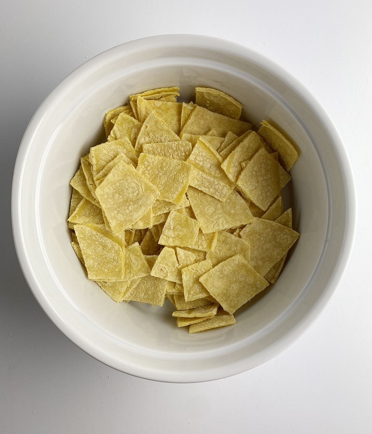 Cut up tortilla pieces in a casserole dish.