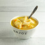 Chicken tortellini soup in a bowl with a spoon.