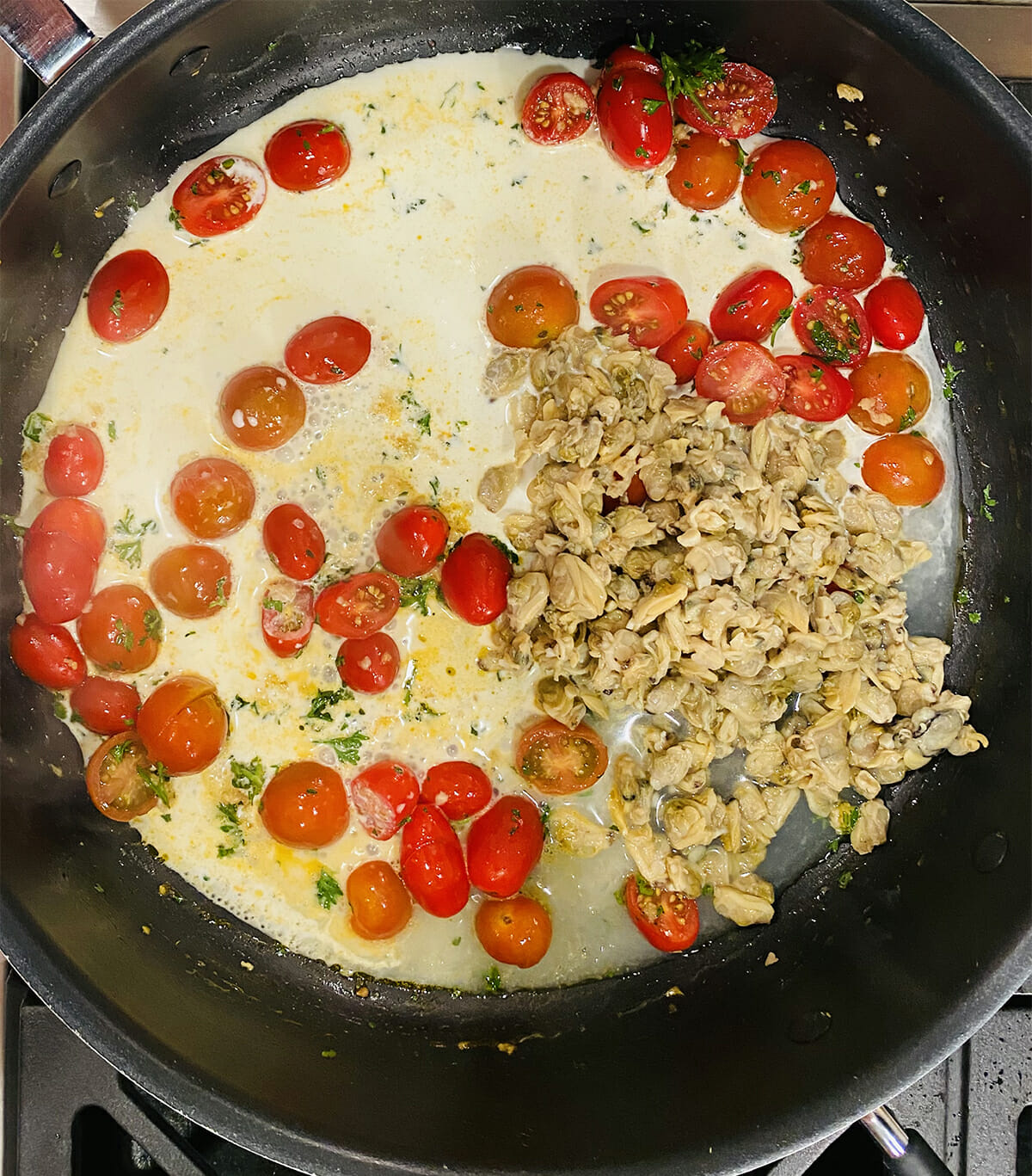 Creamy clam sauce mixture in skillet.