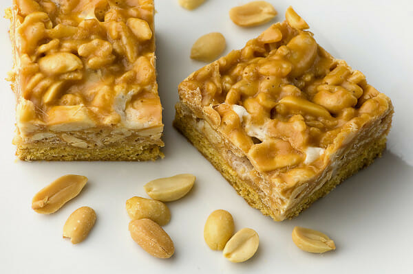Payday Cookie Bars with peanuts on a counter.