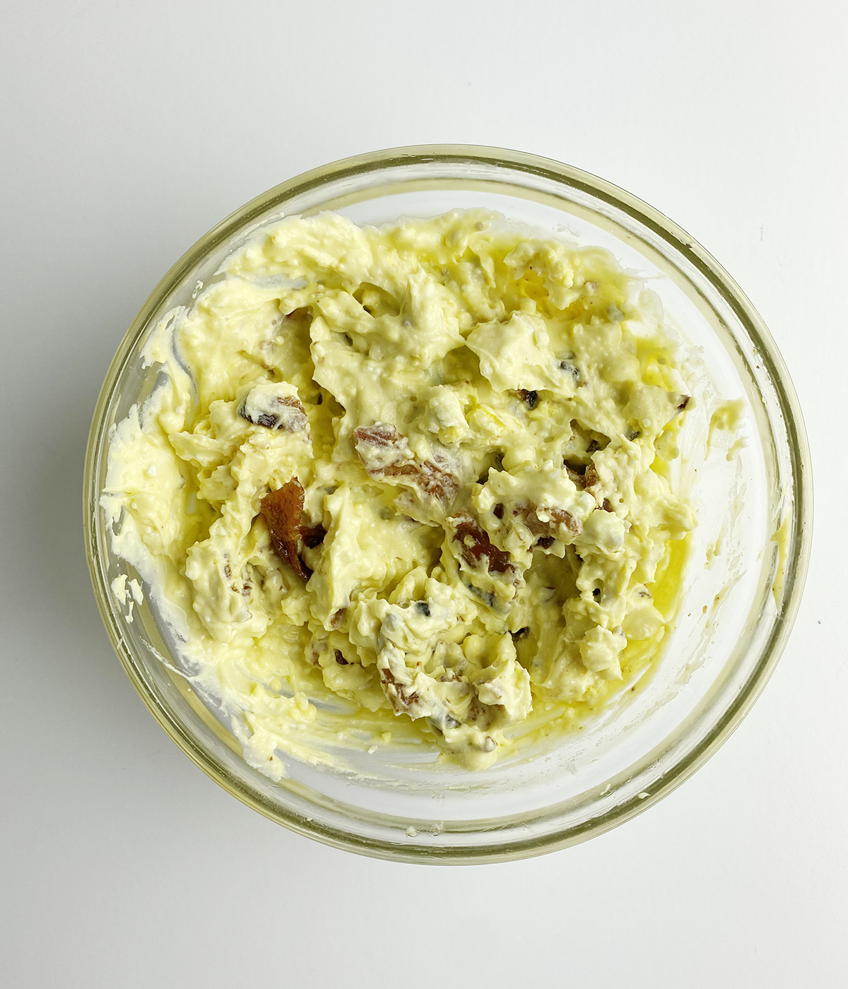 Bacon blue cheese deviled egg yolk mixture in a mixing bowl.
