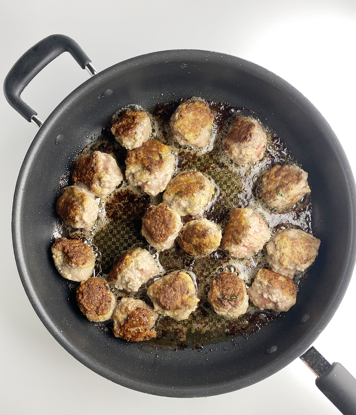 Cooked meatballs in a skillet.