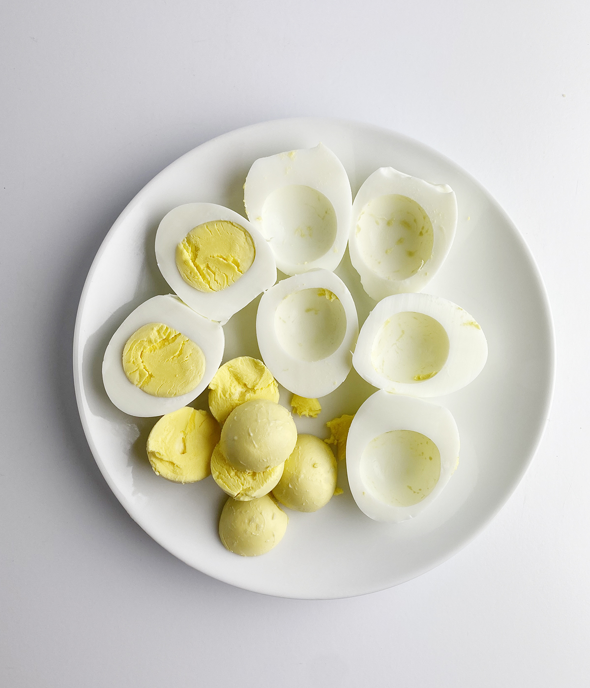 Hard boiled eggs with the yolks being removed.
