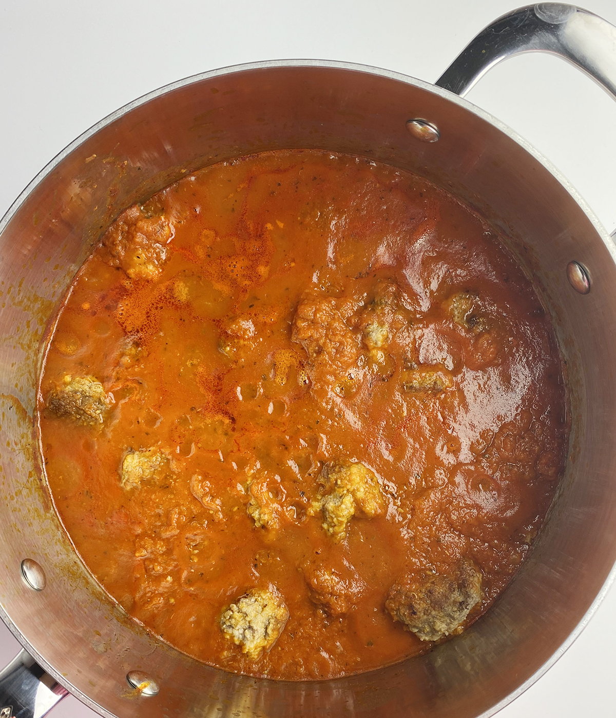 Meatballs and tomato sauce in a pot.