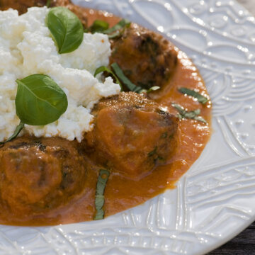 Meatballs with fresh ricotta and tomato sauce in a bowl.