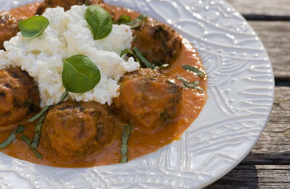 Meatballs with fresh ricotta and tomato sauce in a bowl.