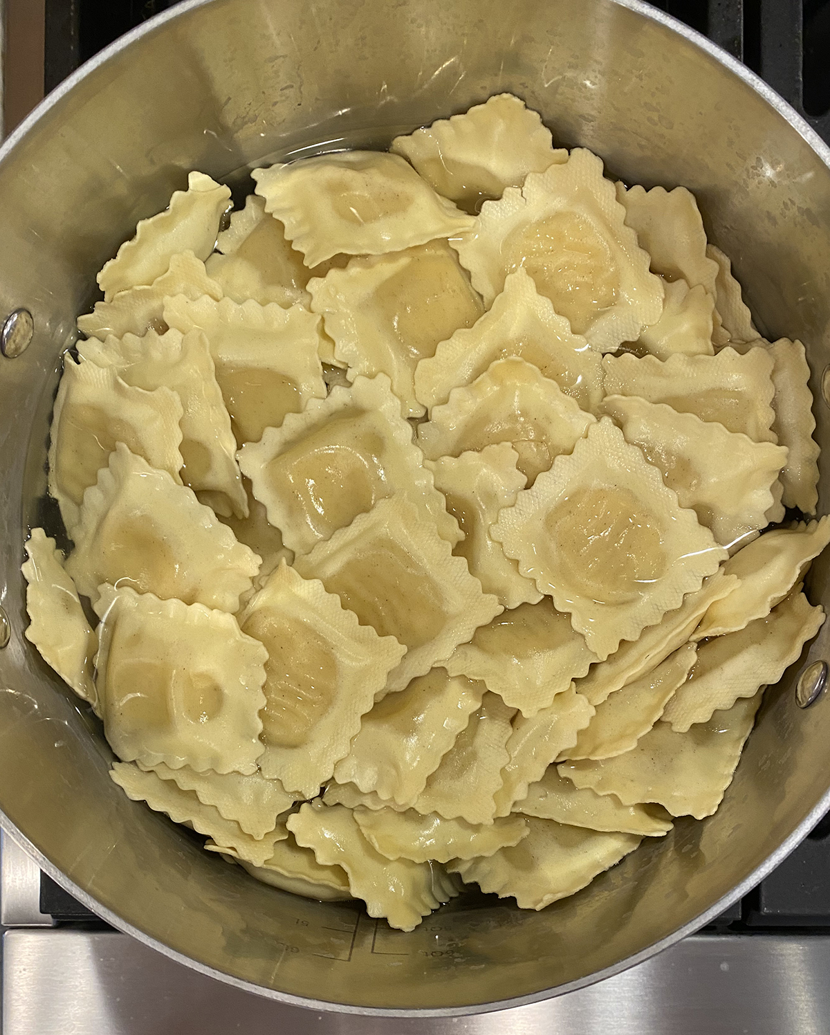 Cooked and drained ravioli in a pot.