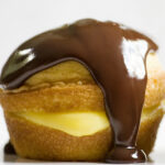 Boston Cream Pie Cupcake with chocolate drizzle.