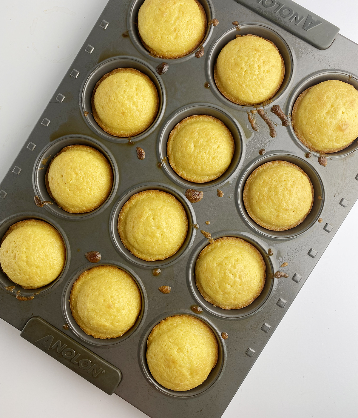 Vanilla cupcakes cooling in a muffin pan.