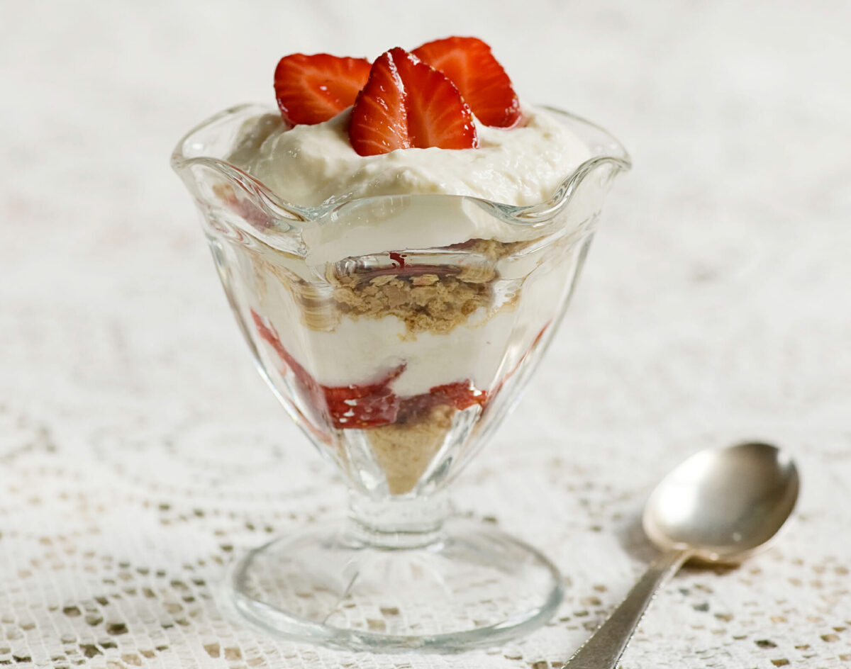 Strawberry cheesecake parfait in a dish with a spoon.