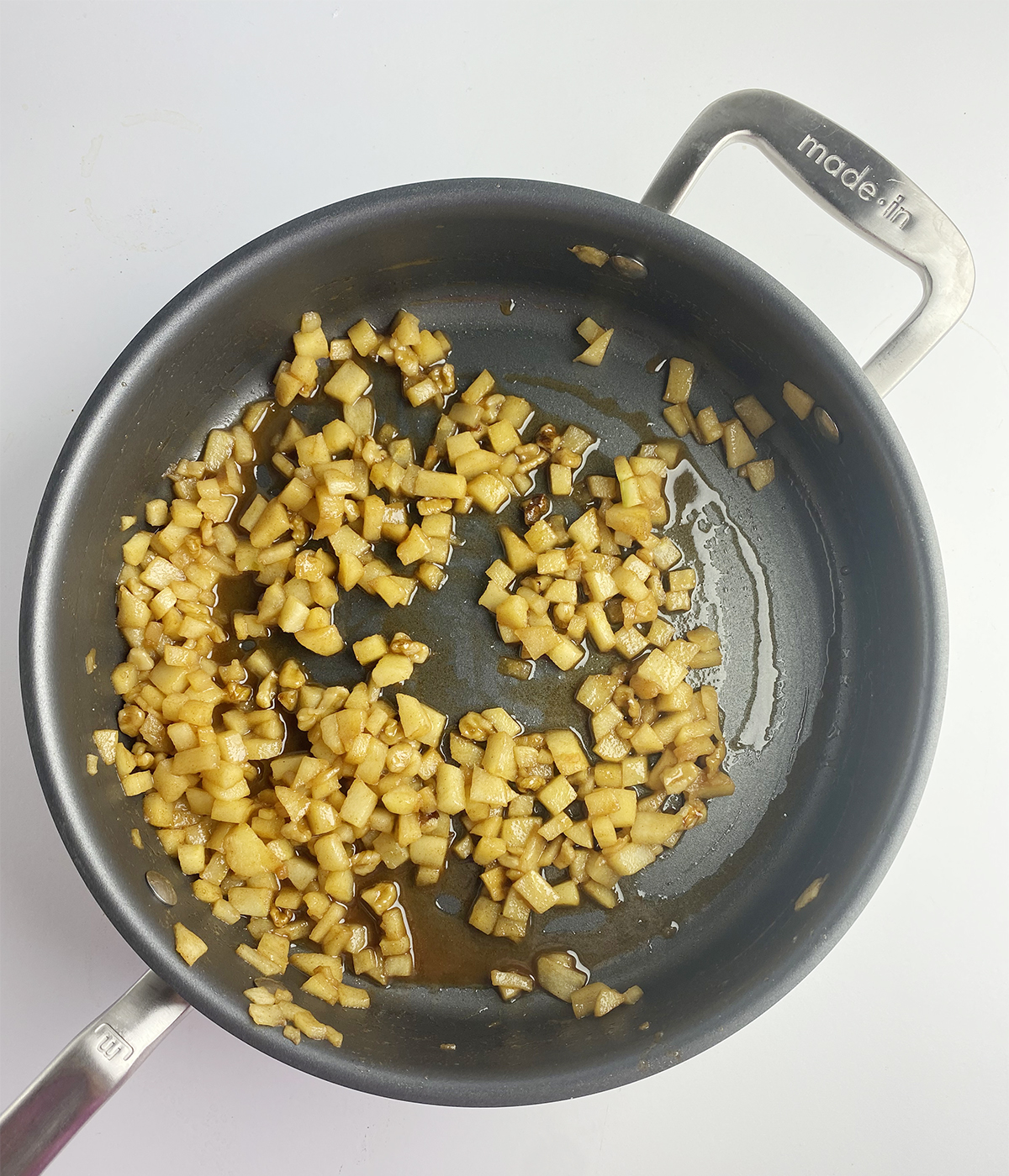 Cooked apple filling for mini apple pies in a skillet.