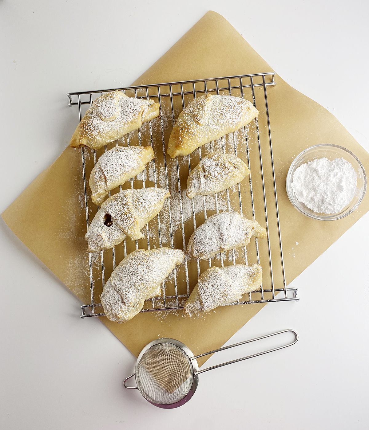 mini apple pies on cooling rack dusted with powdered sugar.