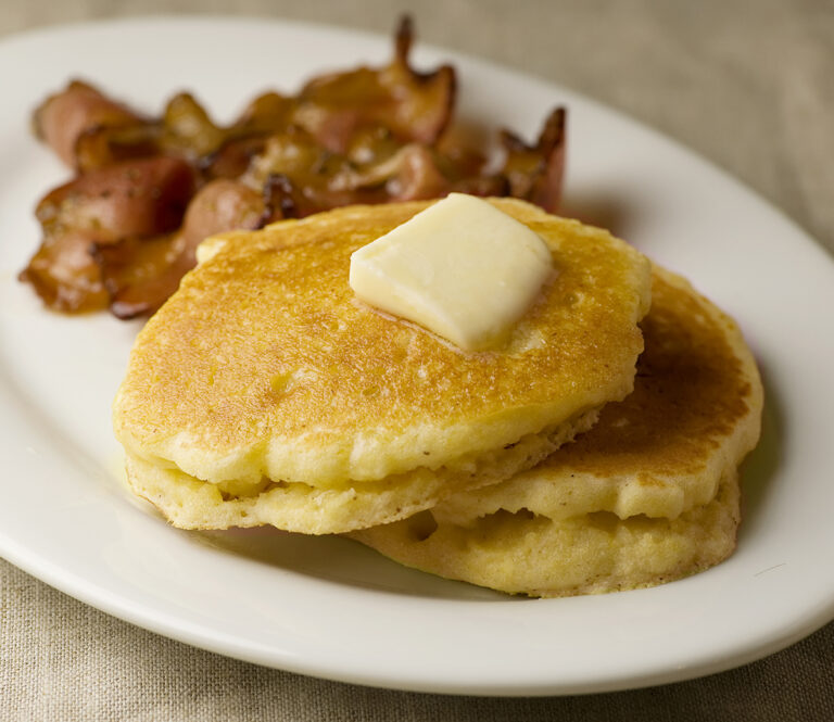 Buttermilk Cornmeal Pancakes on a plate with bacon.
