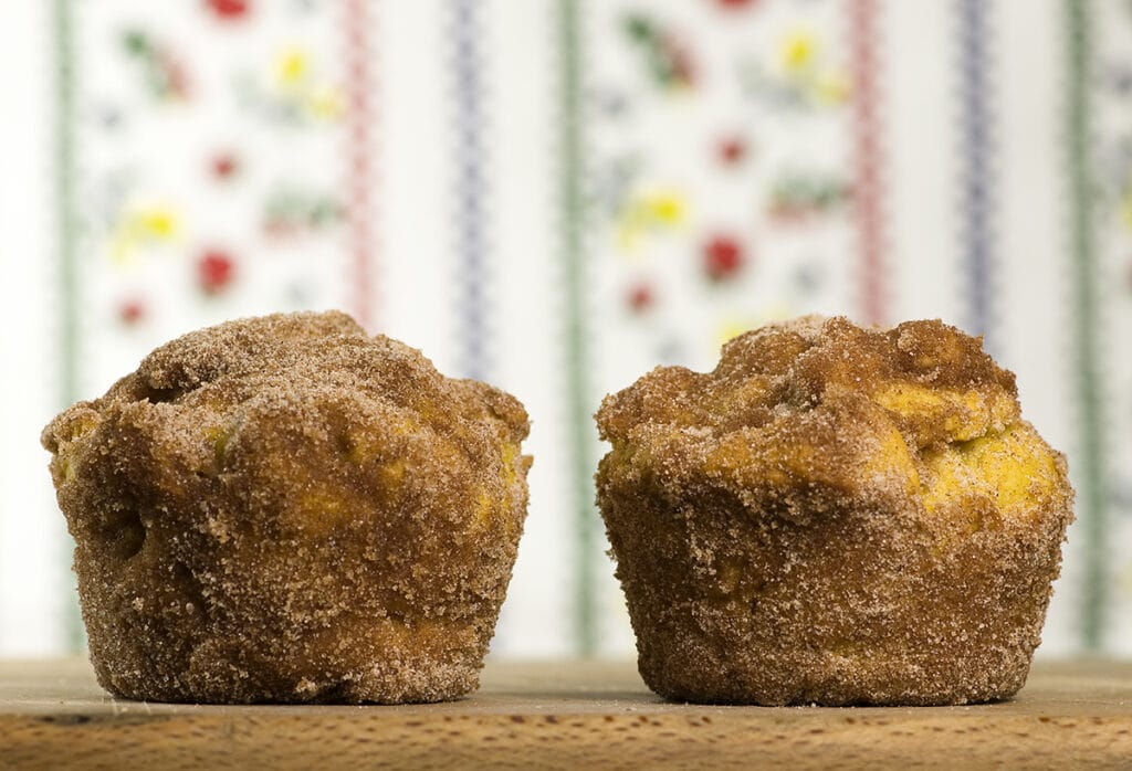Two pumpkin doughnut muffins on a wooden board.