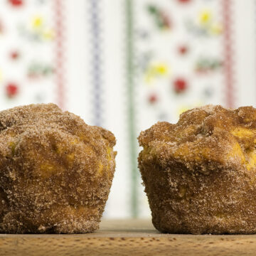 Two pumpkin doughnut muffins on a wooden board.