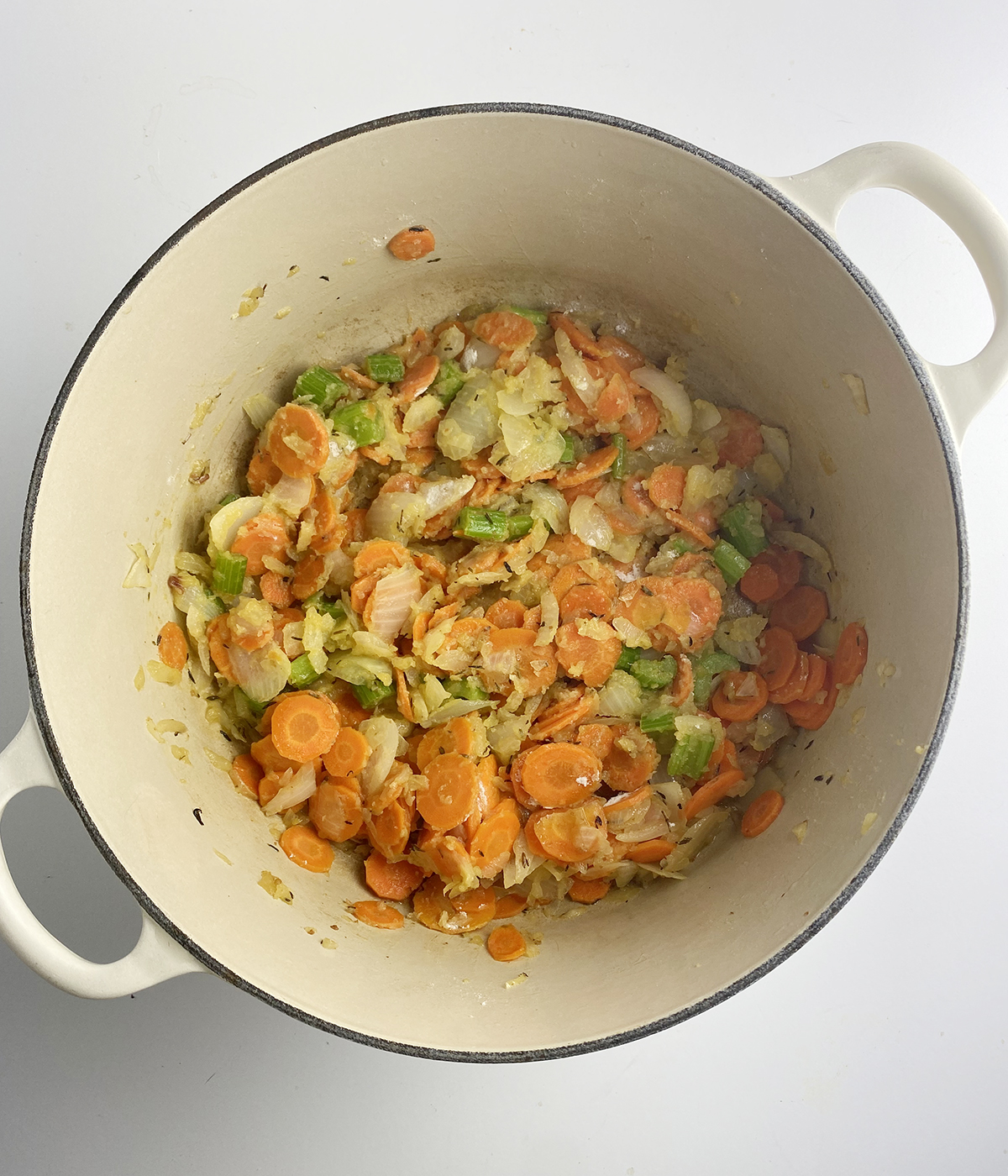 Cooked carrots onions and celery in a Dutch oven.