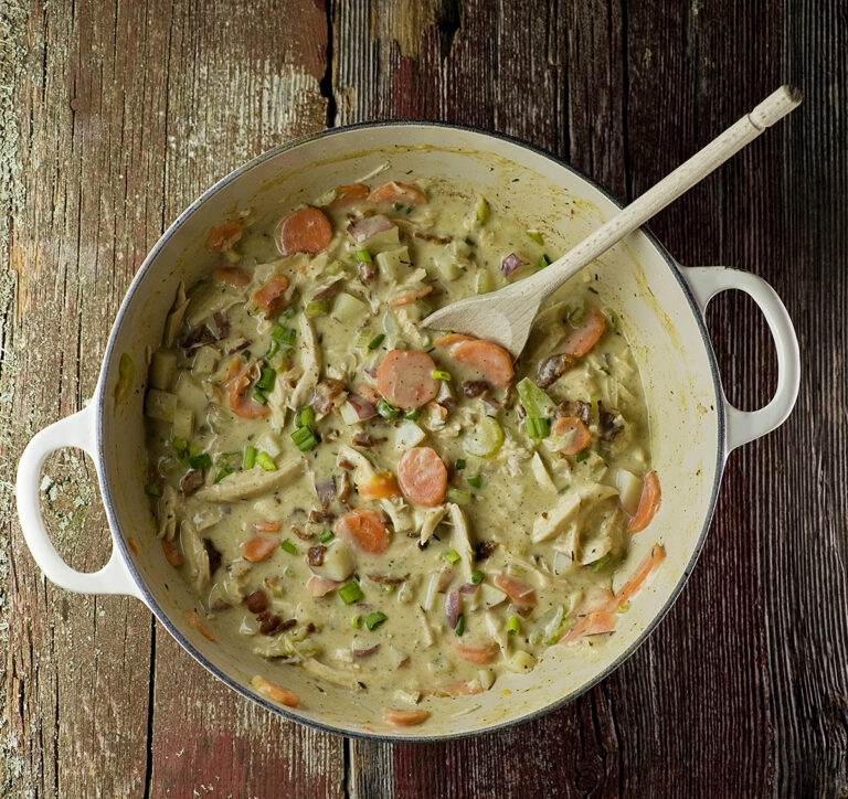Creamy chicken stew on a wooden table.