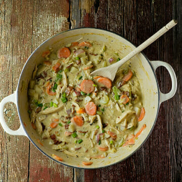 Finished creamy chicken stew in a Dutch oven on the counter.