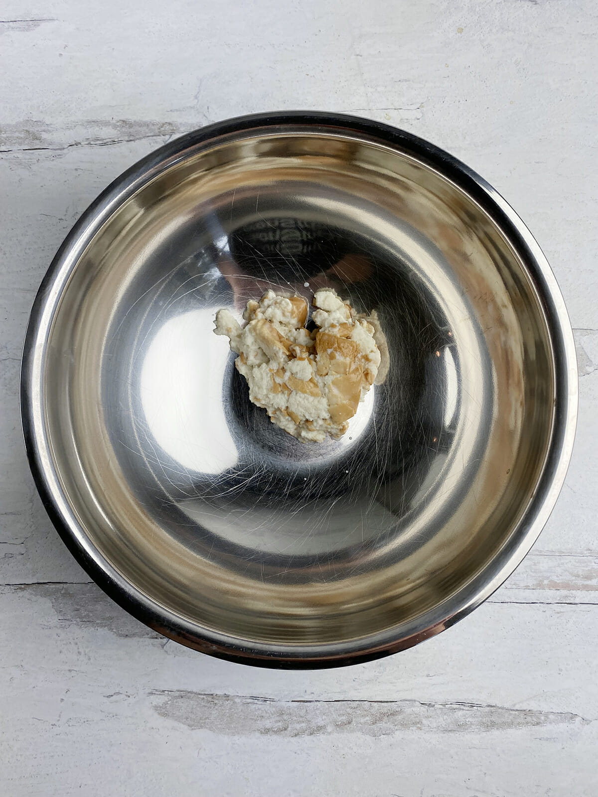 Milk and bread for ricotta meatloaf in a metal bowl.