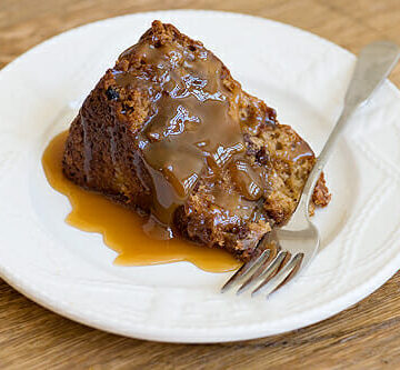 A slice of easy apple cake with caramel sauce on a plate with a fork.